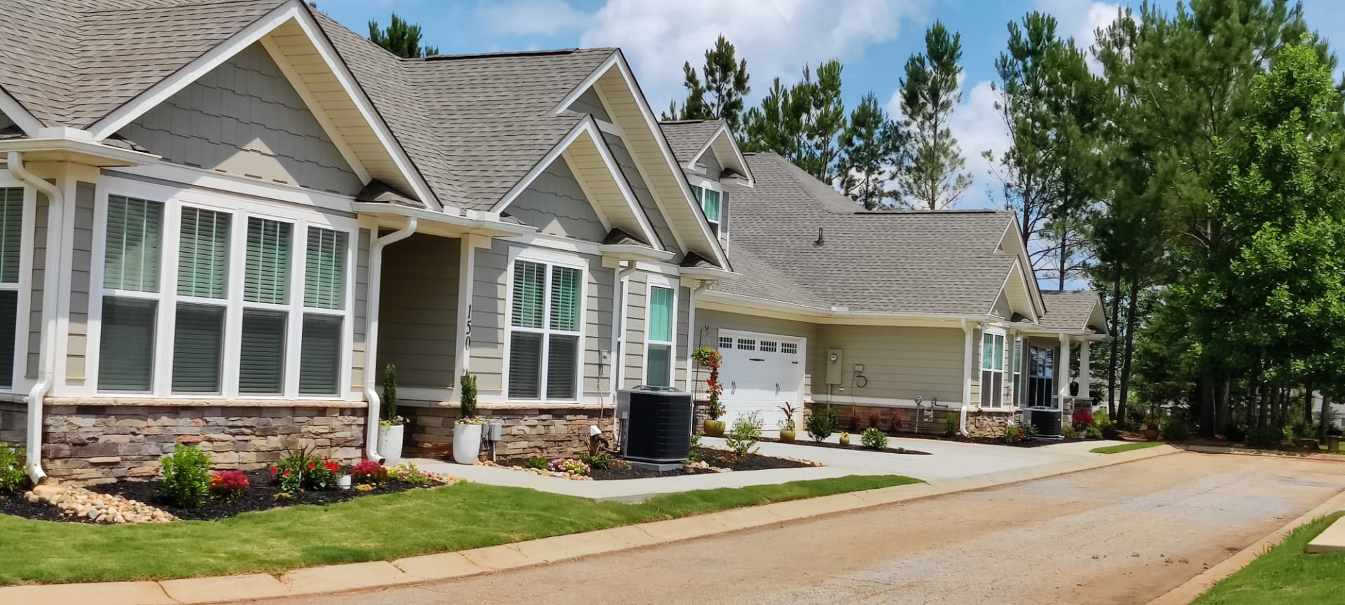 A row of completed craftsman senior townhomes with stone accents